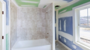 Bathroom remodel progresses as drywall is smoothed