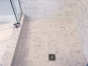 Skilled tradework installation of ceramic tiles in mosaic style in modern shower, home improvement